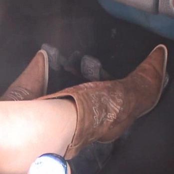 Mandie Aggressively Driving the Bug in Brown Cowgirl Boots, 1 of 2